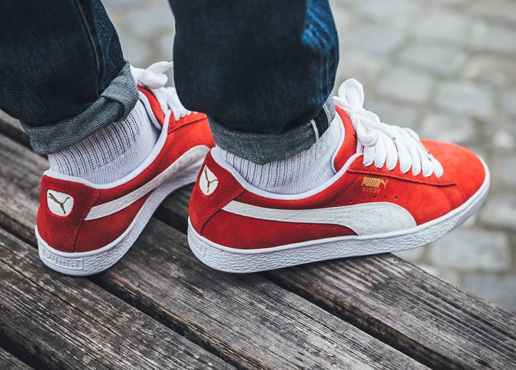 red suede pumas on feet